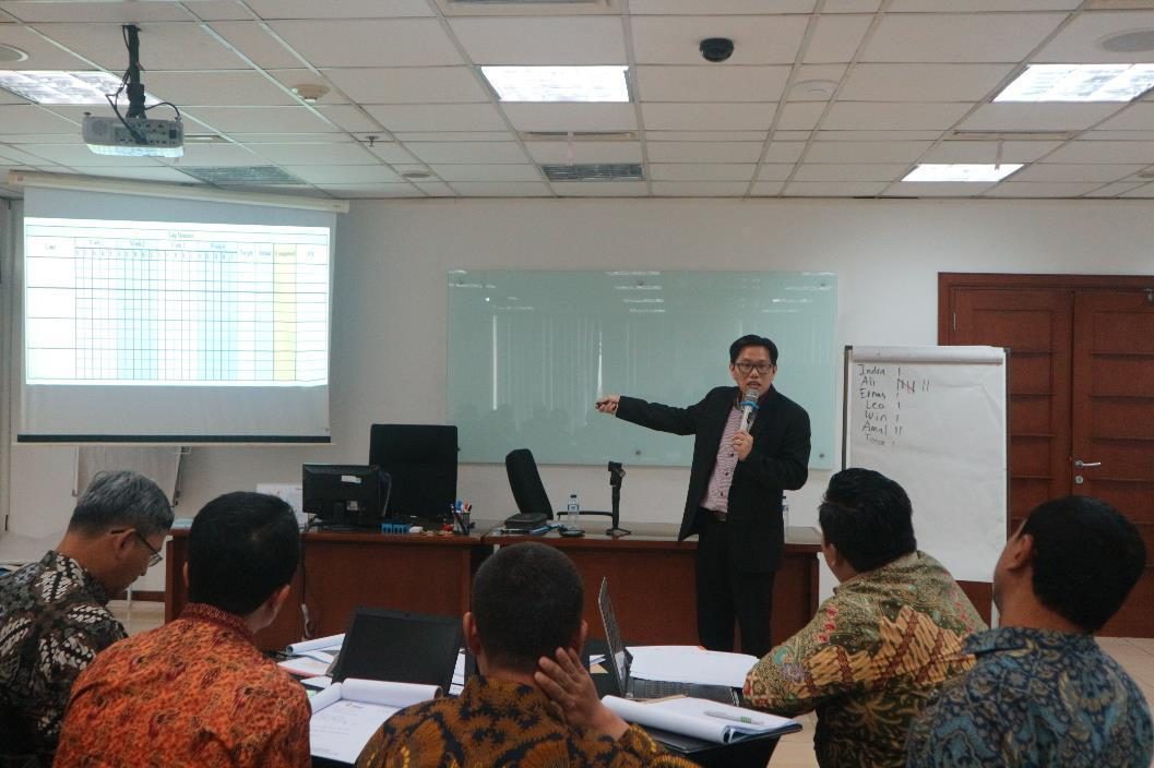 Coach Ronnie Francis memfasilitasi sesi pelatihan di depan kelas korporasi